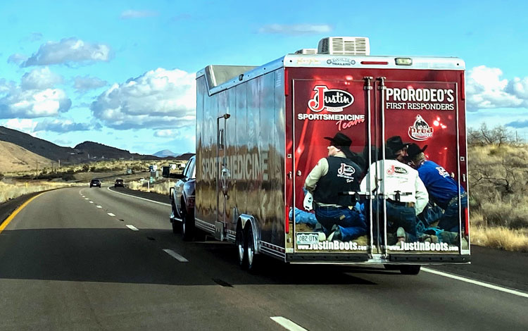 Justin Sportsmedicine® Trailer hauling down the road with a blue sky and mountains.